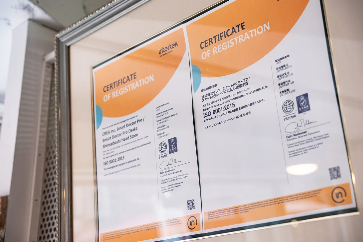 スマートドクタープロ（株式会社クレア）のISO9001:2015認証書——intertek・UKAS認定機関による品質マネジメントシステム国際認証。認証登録番号10733。スマートフォン・タブレットパーツの輸入・修理に適用。大阪心斎橋本店に現物を掲示しています。