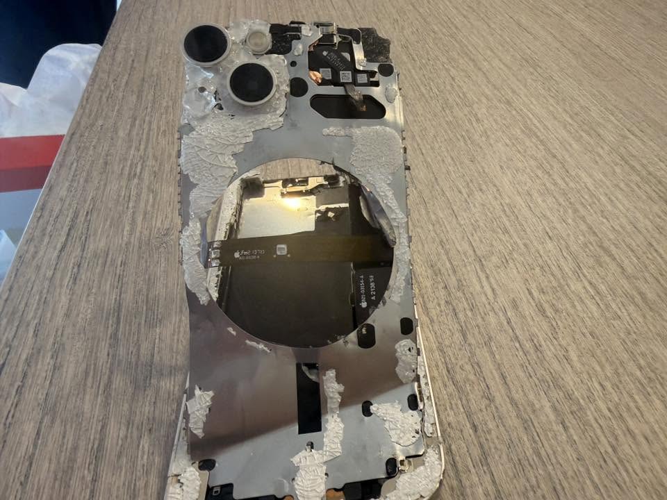 内部フレームと基板が露出したiPhone 13の裏面。車に踏まれて基板中枢まで損傷（データ復旧診断）