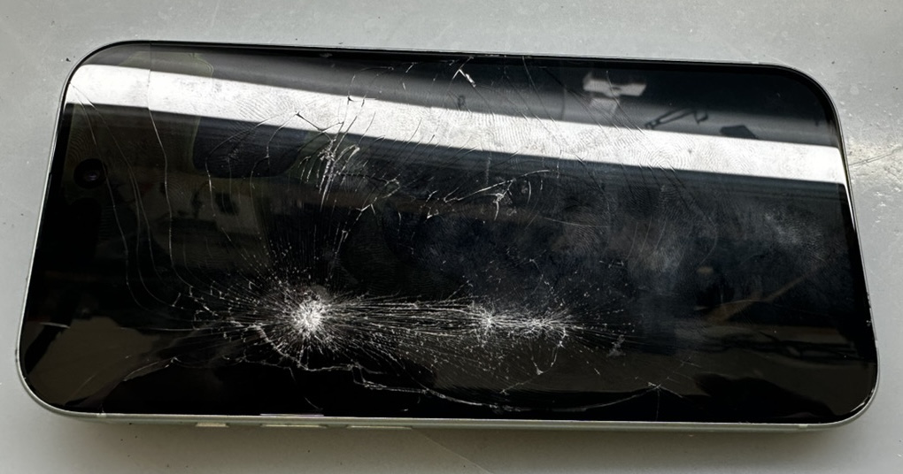 駅の階段で落として激しく割れたiPhone 15のフロントパネル（画面破損の実機写真）
