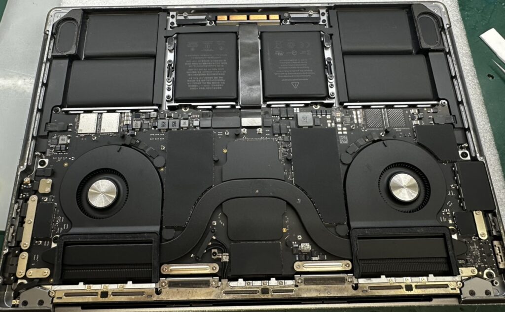 MacBook Pro M1を分解し、デュアルファン・大型バッテリー・ロジックボードの状態を精密診断している様子（実機写真）