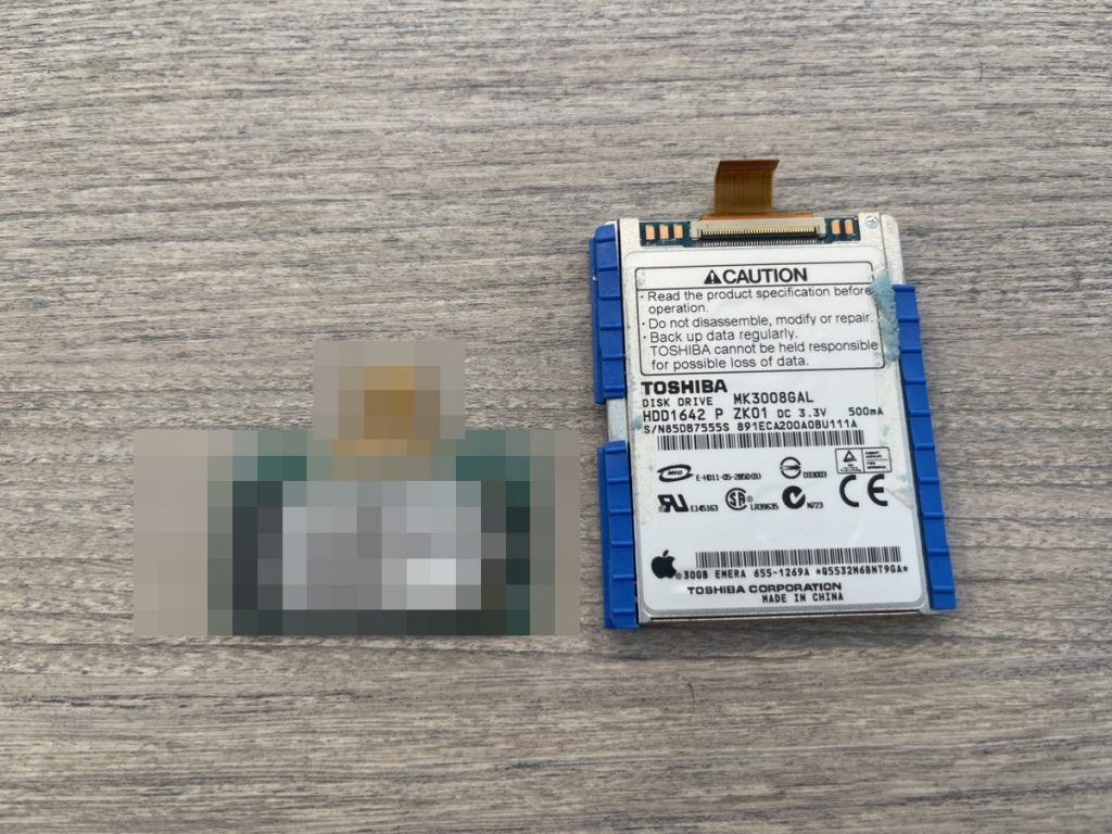 iPod classicに換装した128GB SSD（左・情報保護のためモザイク加工）と、取り外した東芝製1.8インチHDD（右）。SSD換装で無音・耐衝撃・大容量化