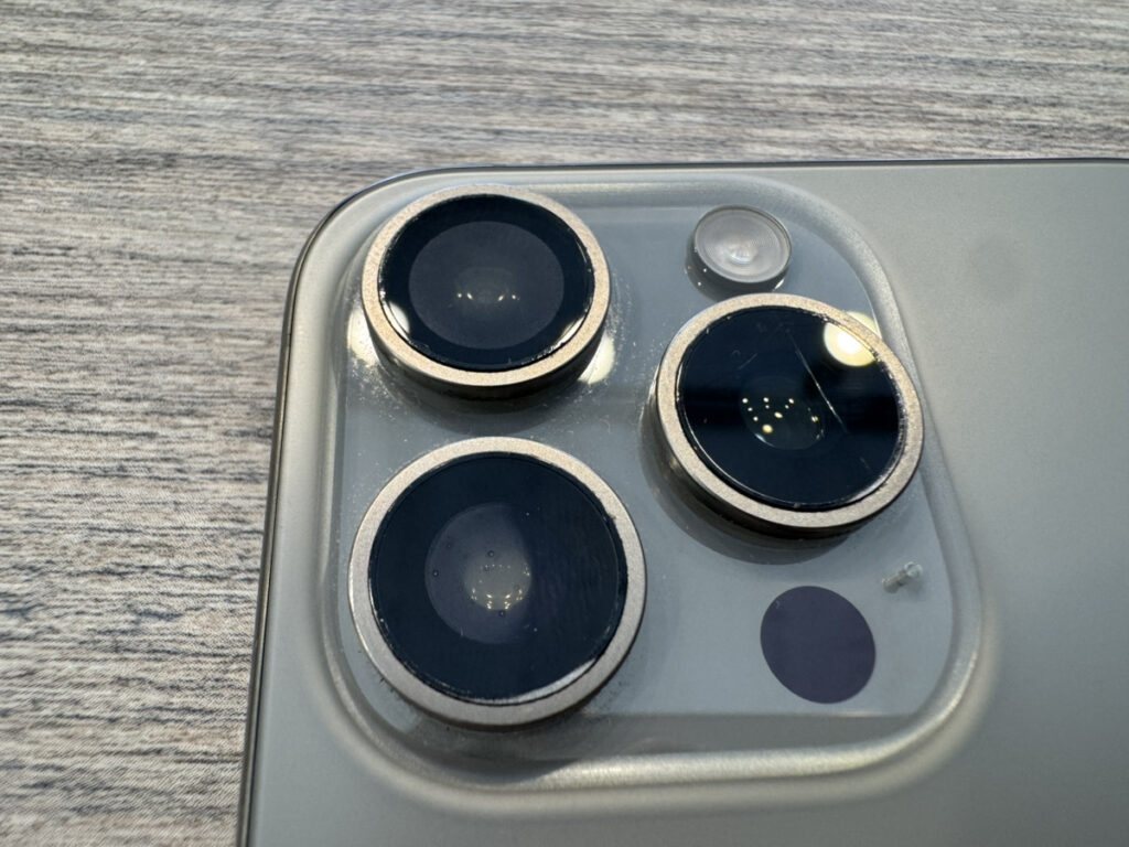 iPhone 15 Proのカメラレンズ内部に付着した水滴と曇り。自覚のない水没を示す典型的なサイン