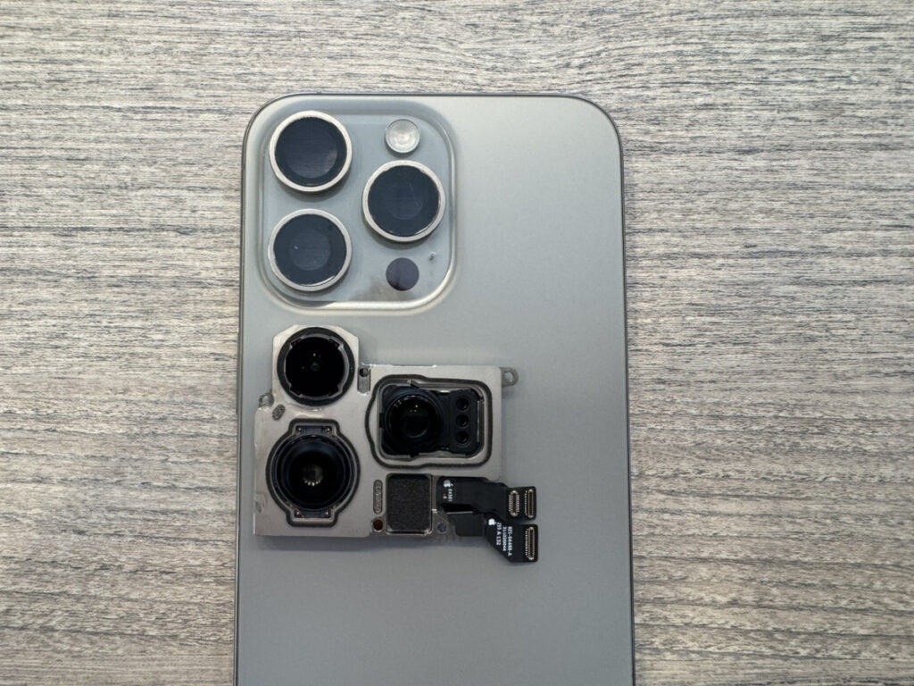iPhone 15 Proの背面カメラユニットを取り外した状態。水滴と曇りが出ていたカメラを交換