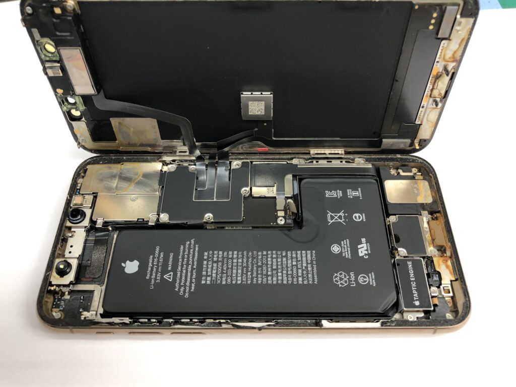 iPhone 11 Proを分解し、基板・バッテリー周りの塩分腐食の範囲を精密診断している様子（実機写真）