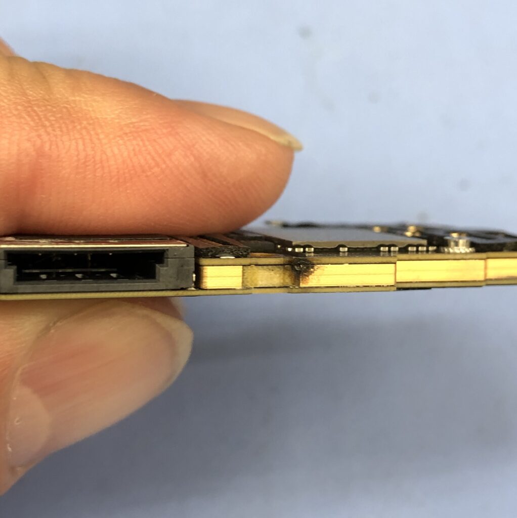 海水没によるショートで一部が焼損したiPhone 11 Proの基板の側面（実機写真）