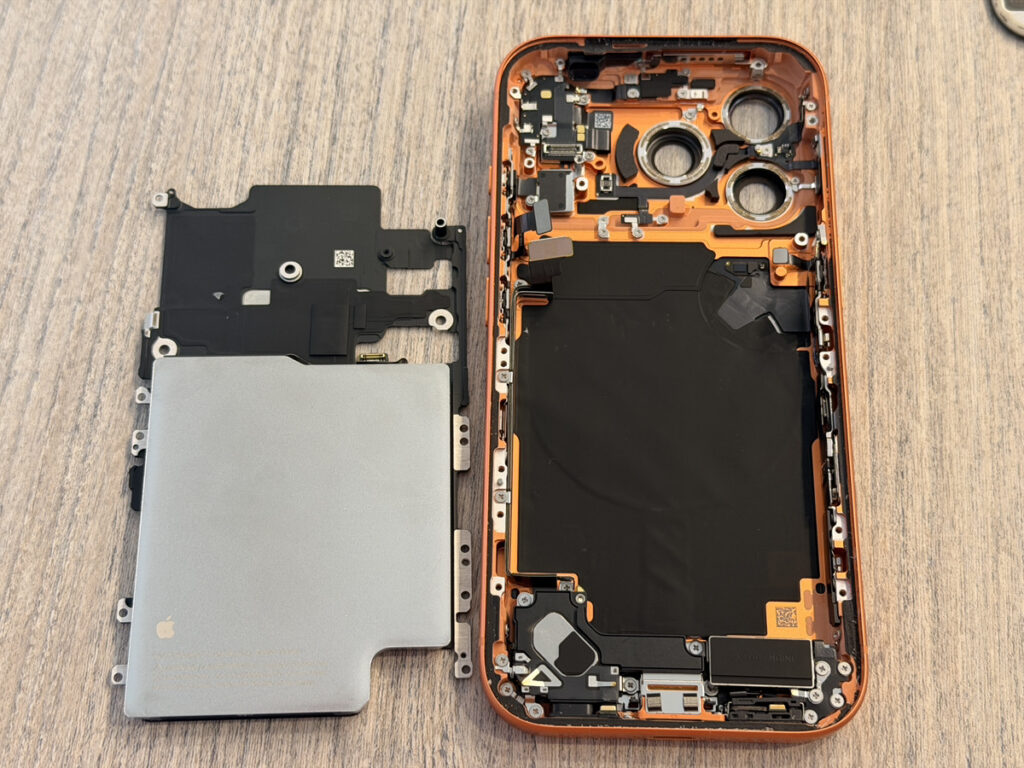 突然電源が入らなくなったiPhone 17 Pro（オレンジ）を分解し、基板を取り外して電源まわりを診断する様子