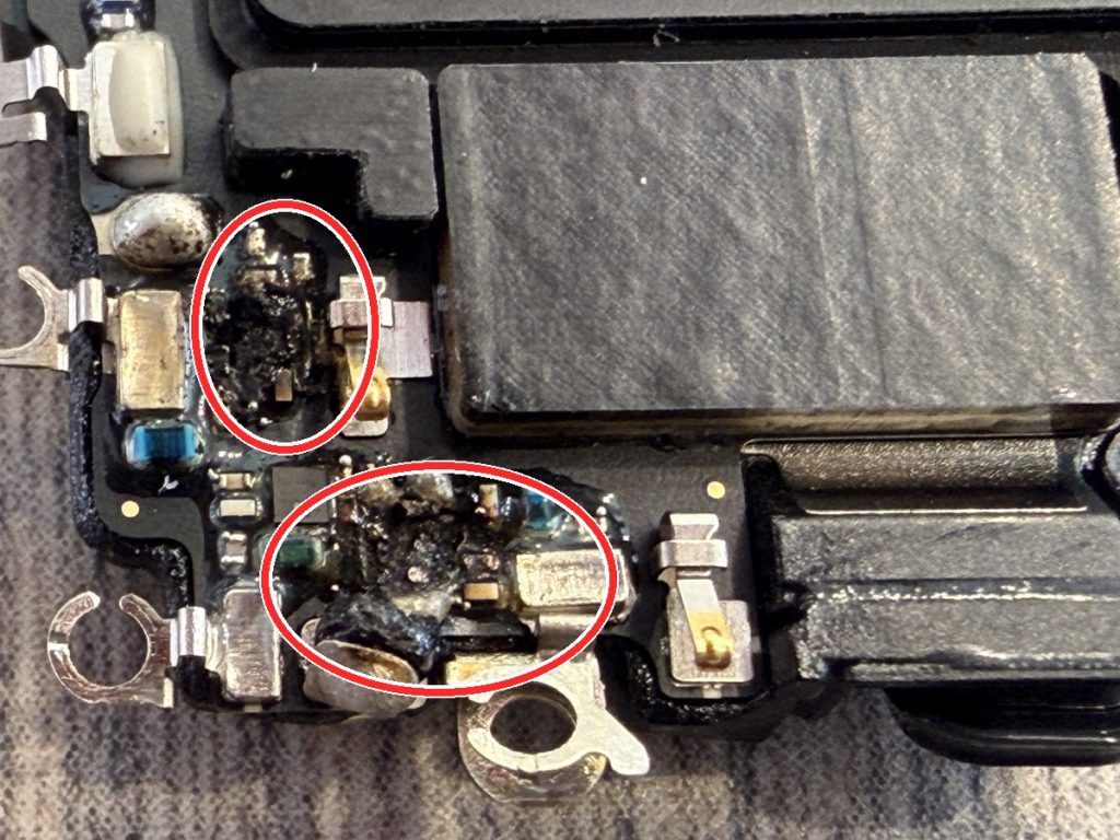 iPhone 16の基板。落下の衝撃で熱損傷した電波系ICを赤い丸で示している。黒く焦げた部分がダメージ箇所