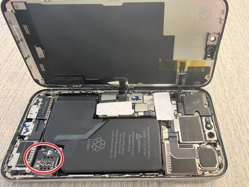 iPhone 15 Pro Max内部。赤丸が後付けのSIM改造基板（iSPM）