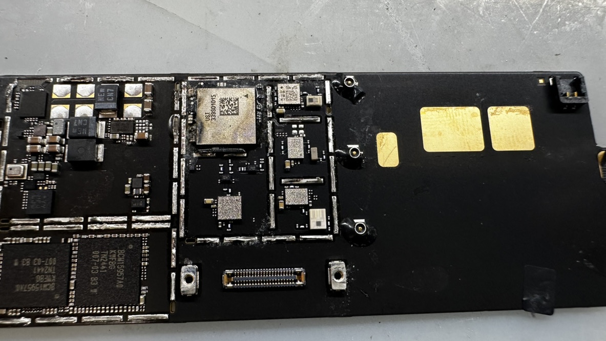 iPad基板のICまわりに白い腐食。水没によるショートの痕