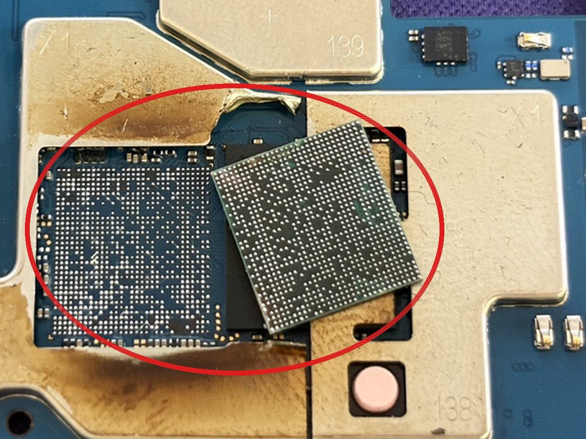 Galaxy A25の基板の拡大。CPUが本来の位置から外れて斜めに載り、その左に空いたパッドが見え、周囲に焦げ跡が広がっている部分を赤丸で示している