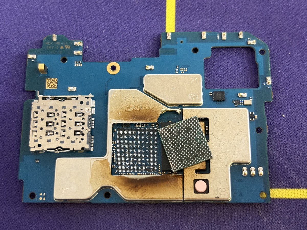 お持ち込み時のGalaxy A25の基板全体。中央のシールドの中でCPUがずれて載り、周囲の金属カバーに焦げ跡が広がっている