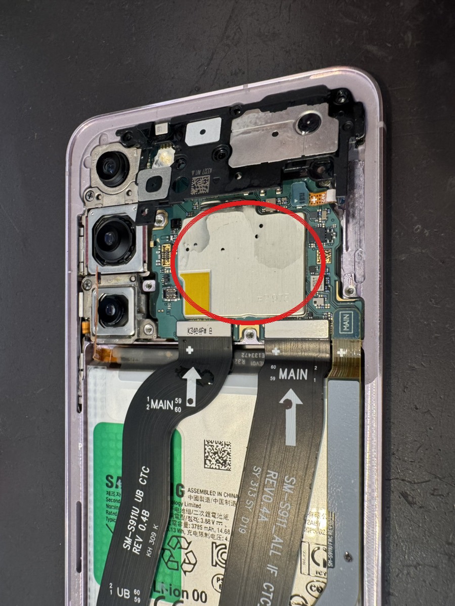 Galaxy S23の内部。基板のシールド上に水が乾いた白い跡が広がっている（赤丸）