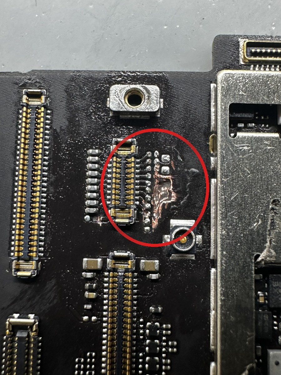 iPad Pro 11の基板の拡大。画面コネクタの脇で基板の保護層が焼けて銅が露出している部分を赤丸で示している