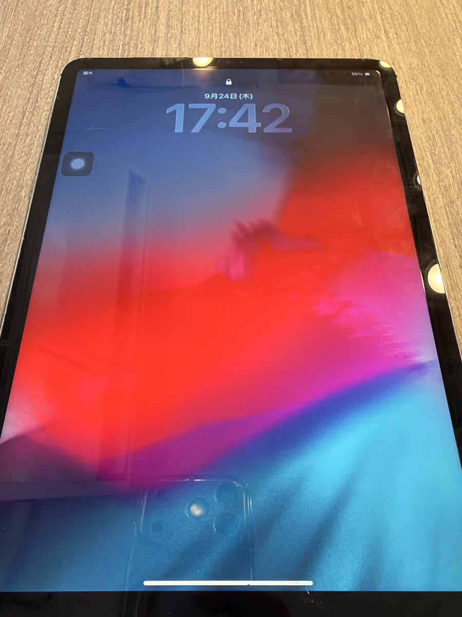 基板修理後のiPad Pro 11。ロック画面が表示され、時計とバッテリー残量が映っている