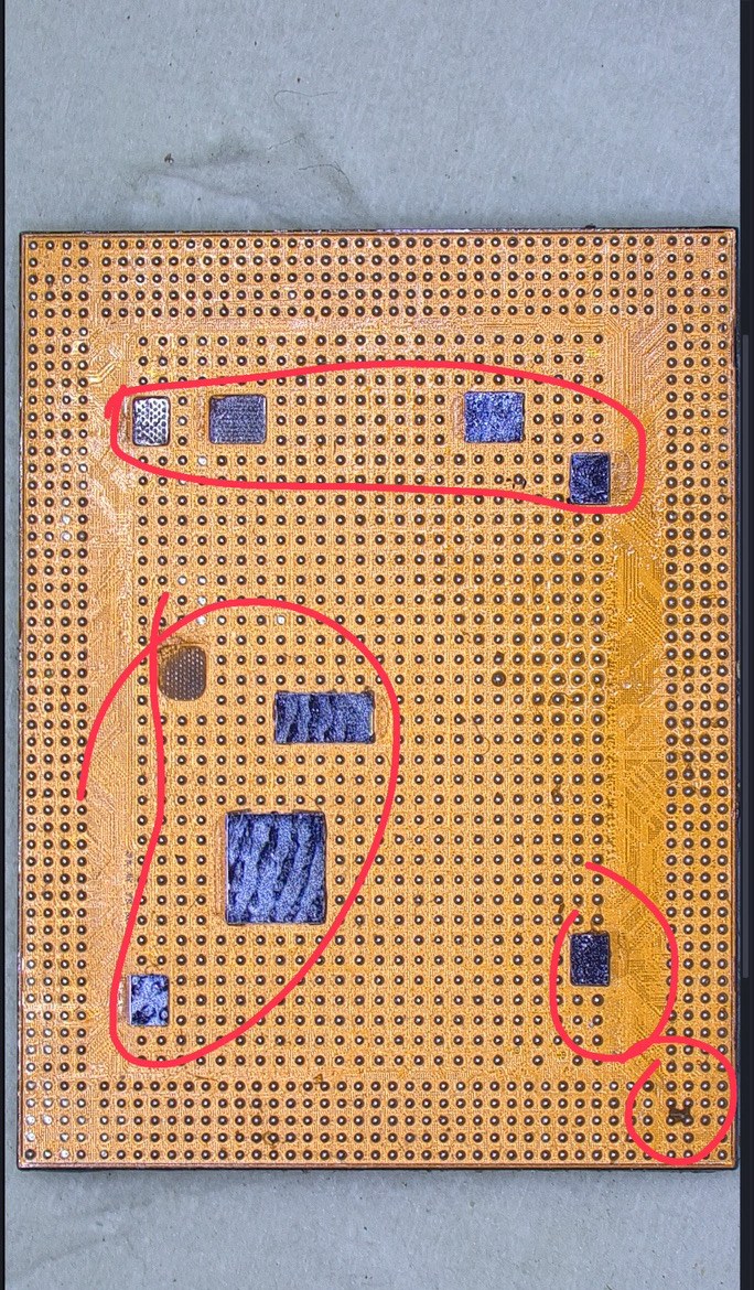 iPhone 16 ProのCPU下面のパッド面。無数のはんだの点の間に青い接着剤の塊が複数残っている部分を赤で囲んでいる