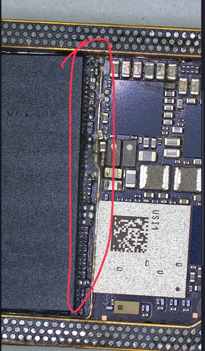 iPhone 16 ProのNANDメモリの縁。基板との境目に接着剤が回り込んで固まっている部分を赤で囲んでいる