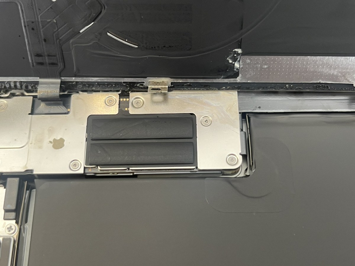 iPhone 16 Pro Maxの基板上部のシールド。水分が乾いた白い痕と、Appleロゴ形の跡が残っている