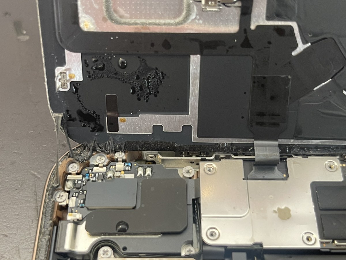 iPhone 16 Pro Maxの内部上部。黒い保護シートの上に多数の水滴が残っている