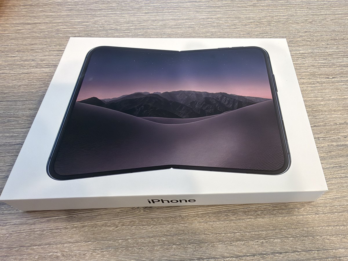 iPhone Duoの白い化粧箱の上に、開いた状態の本体が置かれている。7.6インチの画面に山と砂丘の壁紙