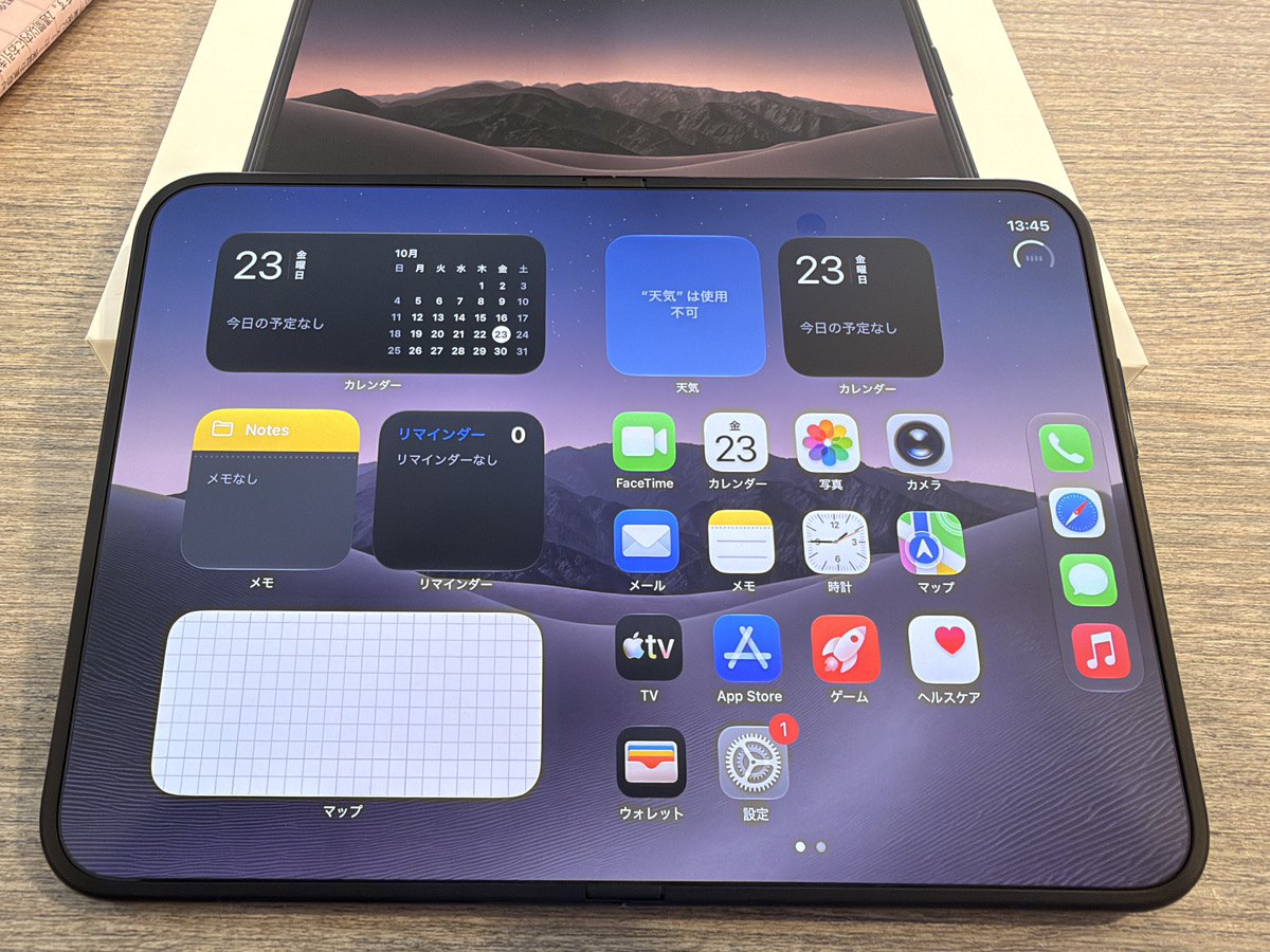 開いた状態のiPhone Duoのホーム画面。左にカレンダーや天気のウィジェット、右にアプリとDockが並ぶ