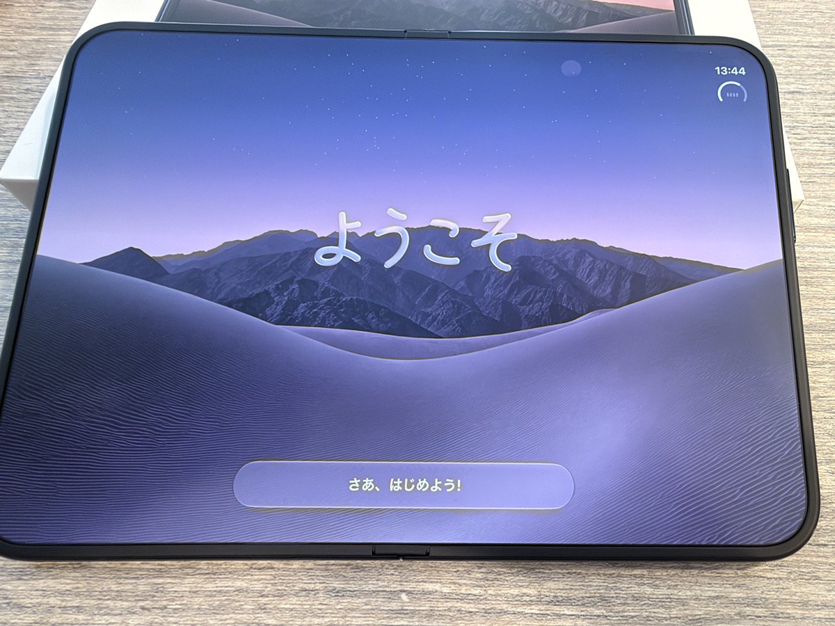iPhone Duoの「ようこそ」画面。横向きの7.6インチ画面いっぱいに壁紙と「さあ、はじめよう！」のボタン
