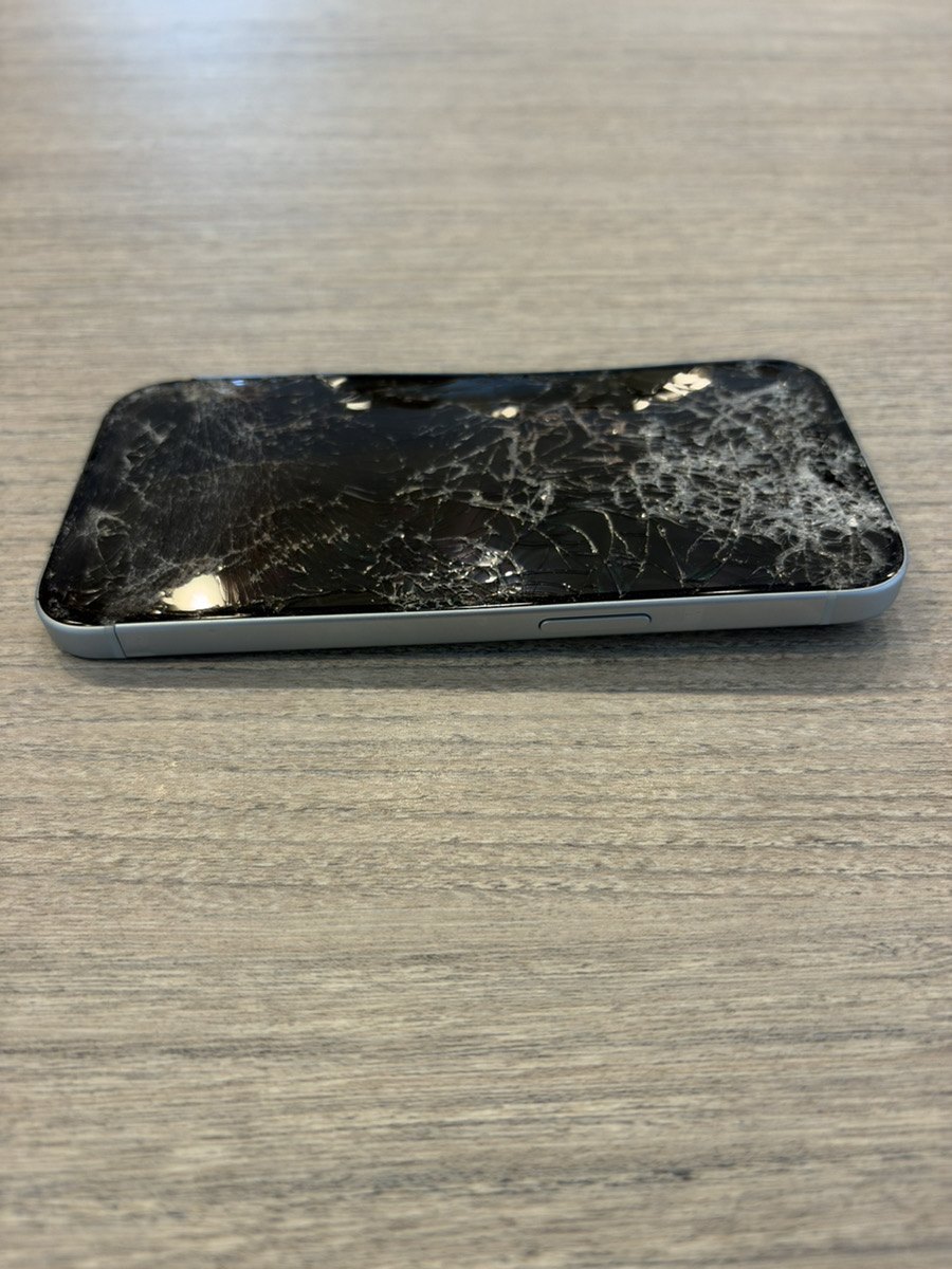 割れた画面のiPhone 15を斜めから見たところ。側面のボタン周辺もフレームが歪んでいる