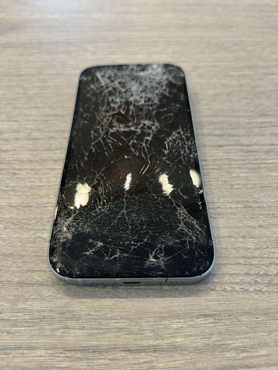 正面から見たiPhone 15。画面全体が細かく割れ、ガラスが白く砕けている