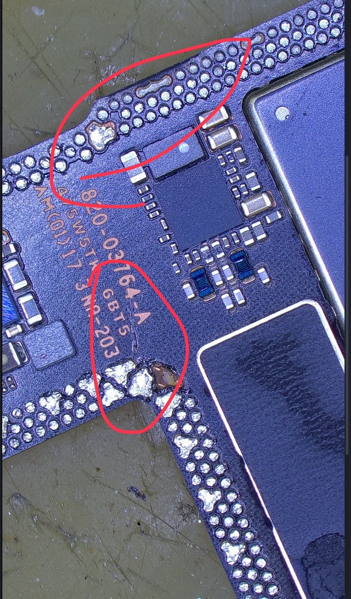 顕微鏡で見たiPhone 17の基板。赤丸で囲んだ2箇所に、衝撃とショートによる穴とクラックが見える